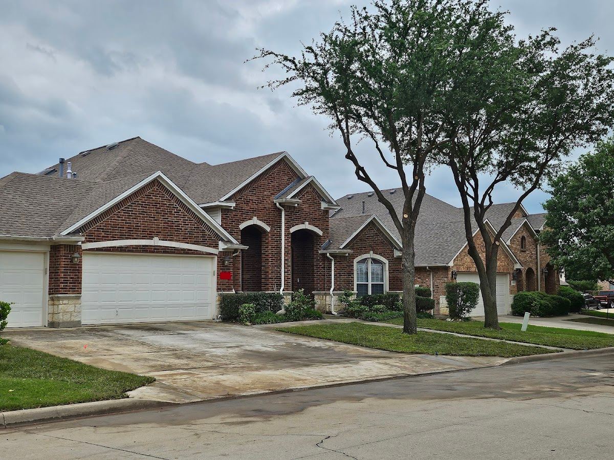 Mature shade trees framing a brick two-story home in a Fort Worth suburb