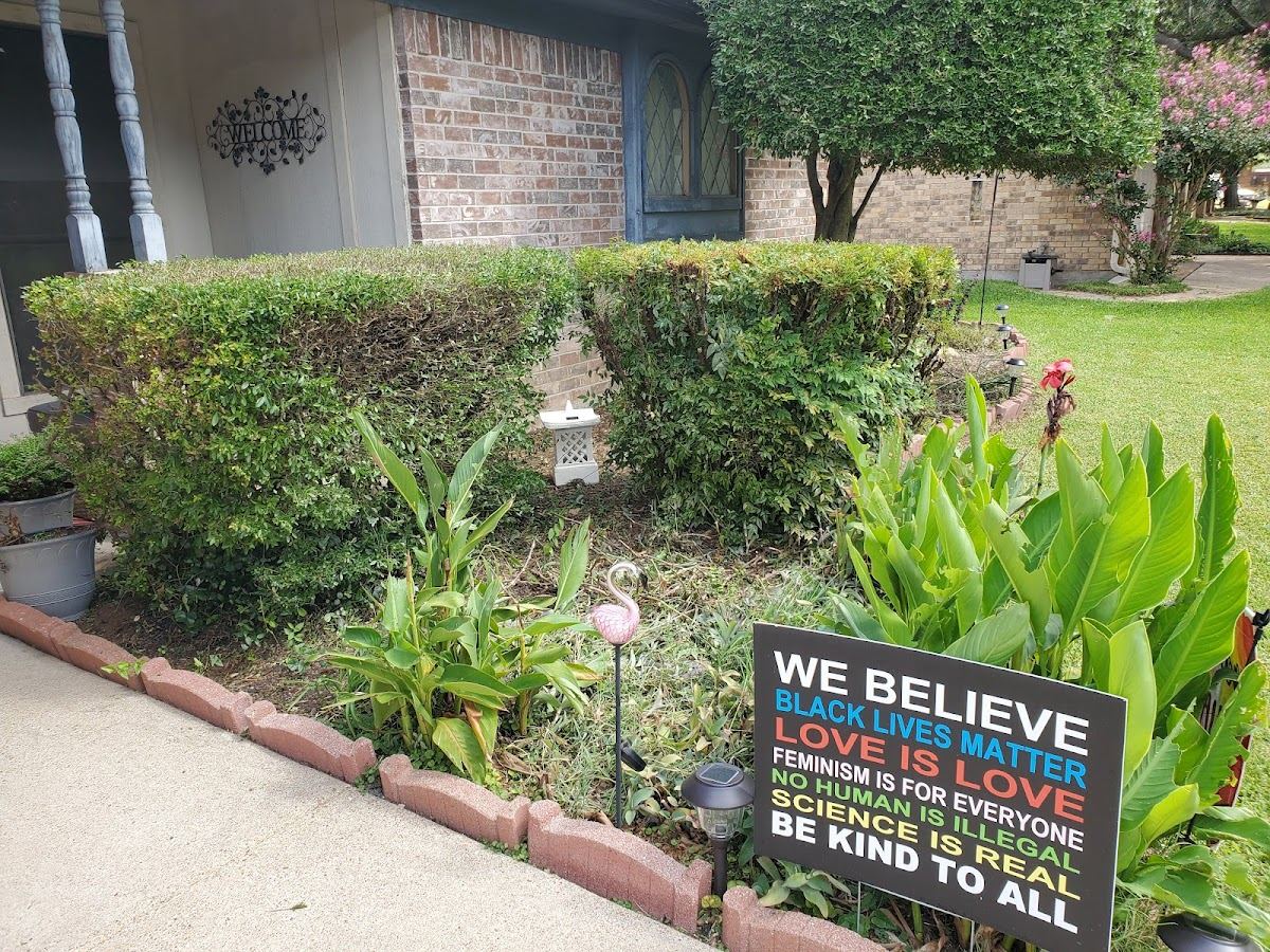 Tidy front-yard flower bed and trimmed hedges at a Fort Worth home