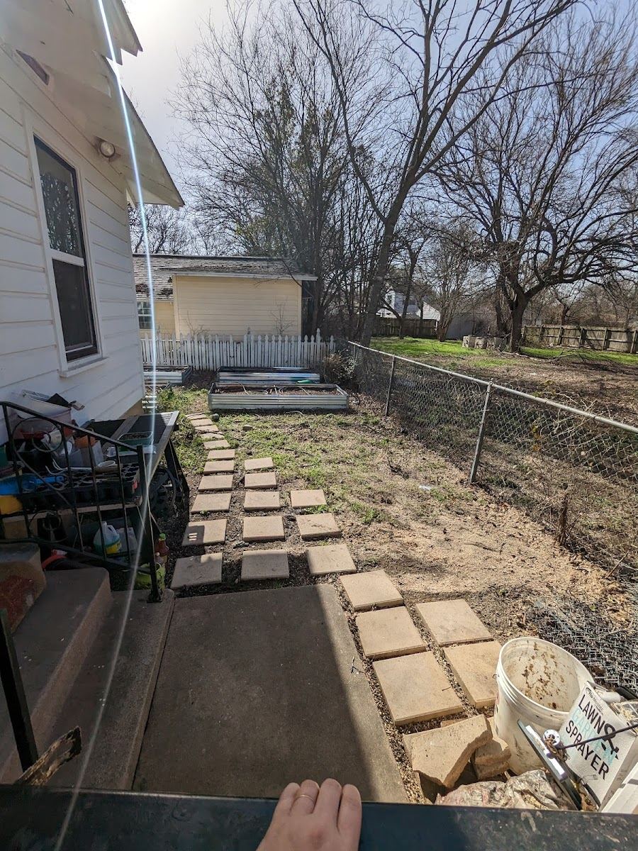 Stone paver walkway and chain-link fenced backyard cleaned up at a Fort Worth property